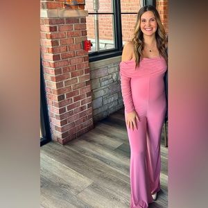 Off the shoulder pink maternity jumpsuit. Stretchy material with a mesh finish.